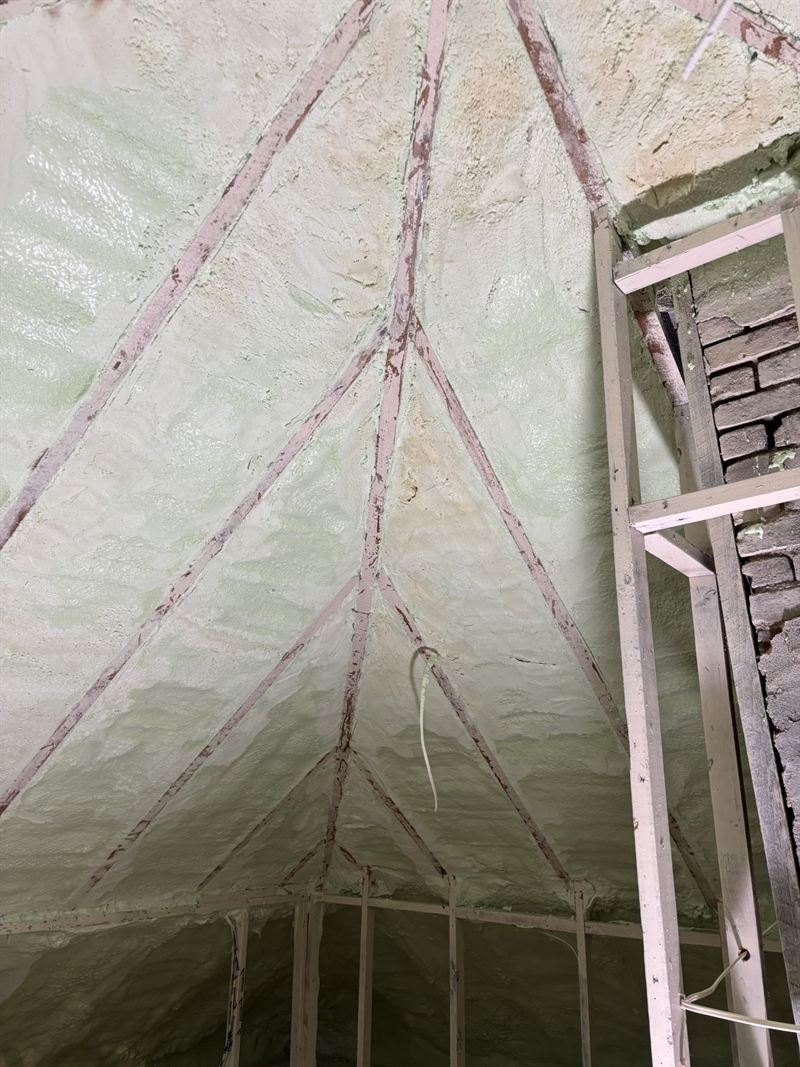 Attic ridge and rafter bays sealed with spray foam.