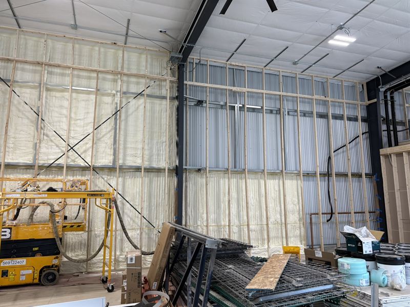 Large commercial steel building with interior framing and panels insulated with spray foam.