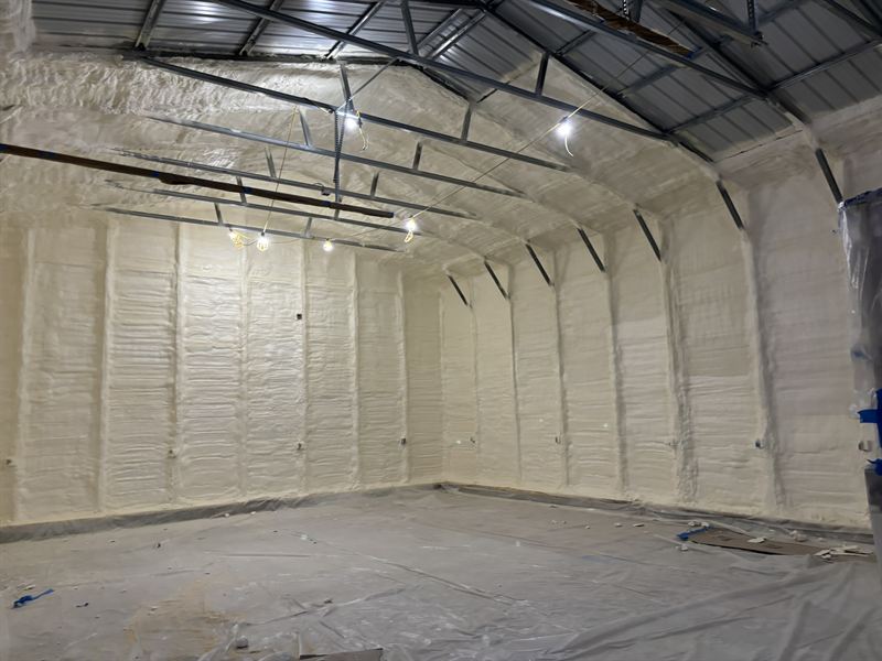 Metal garage with every wall and the full ceiling coated in white closed-cell foam.